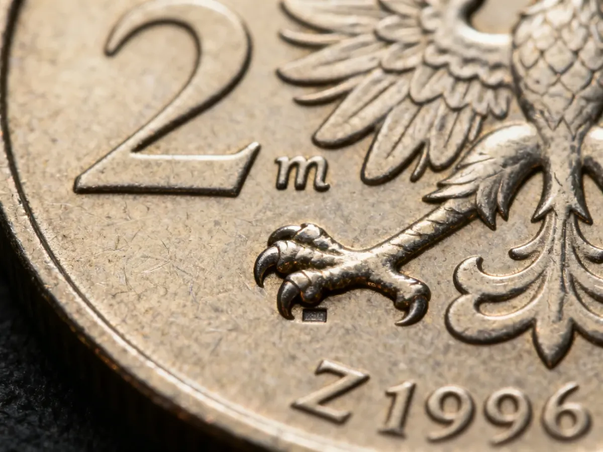 Zbliżenie znaku mennicy „m” nad „w” pod łapą orła na monecie