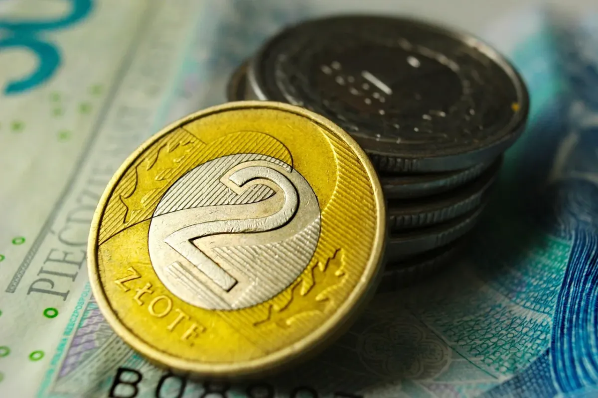 Stos złotych monet symbolizujący bogactwo, oszczędności oraz sukces finansowy.